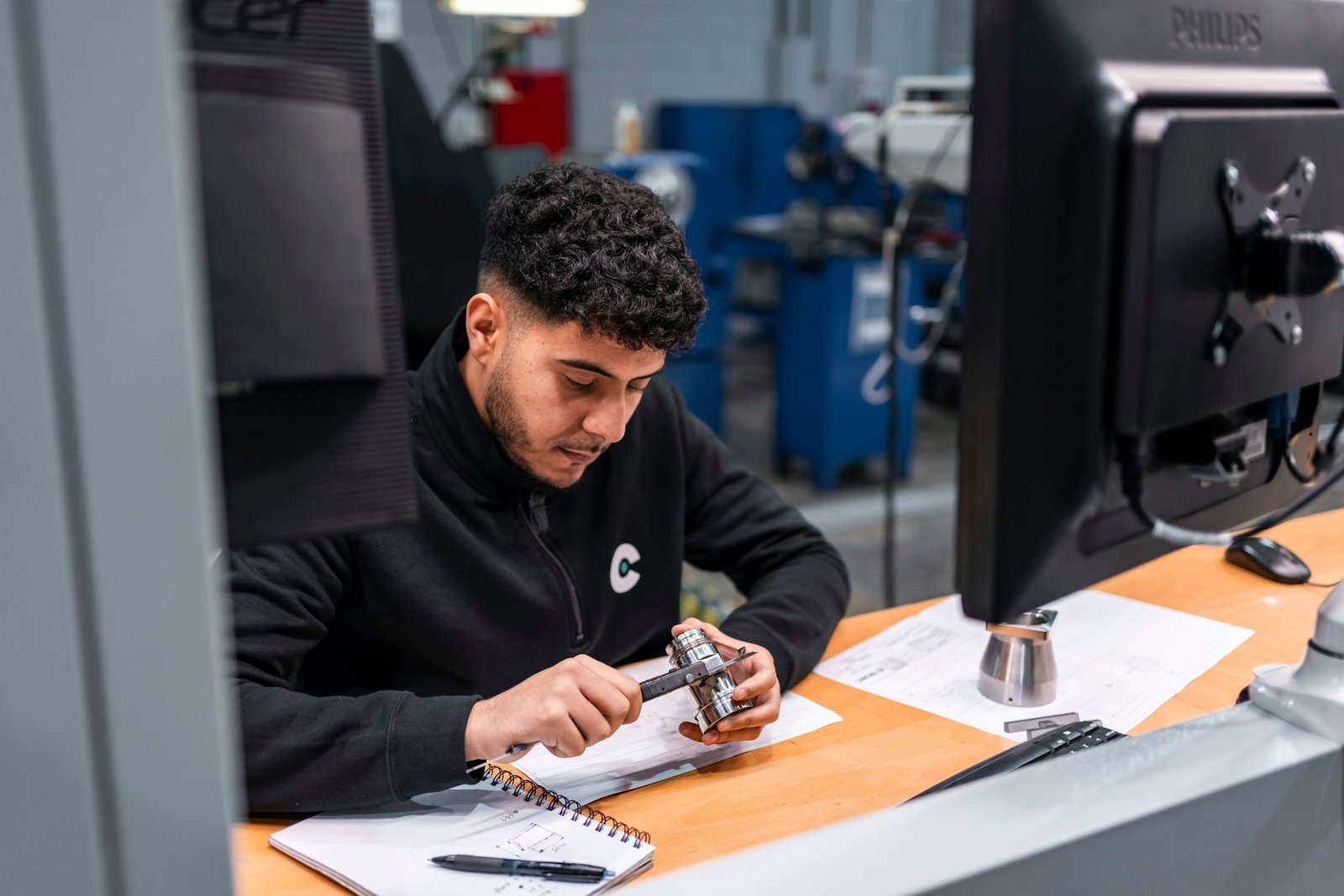 Técnico em bancada de trabalho analisando peça industrial